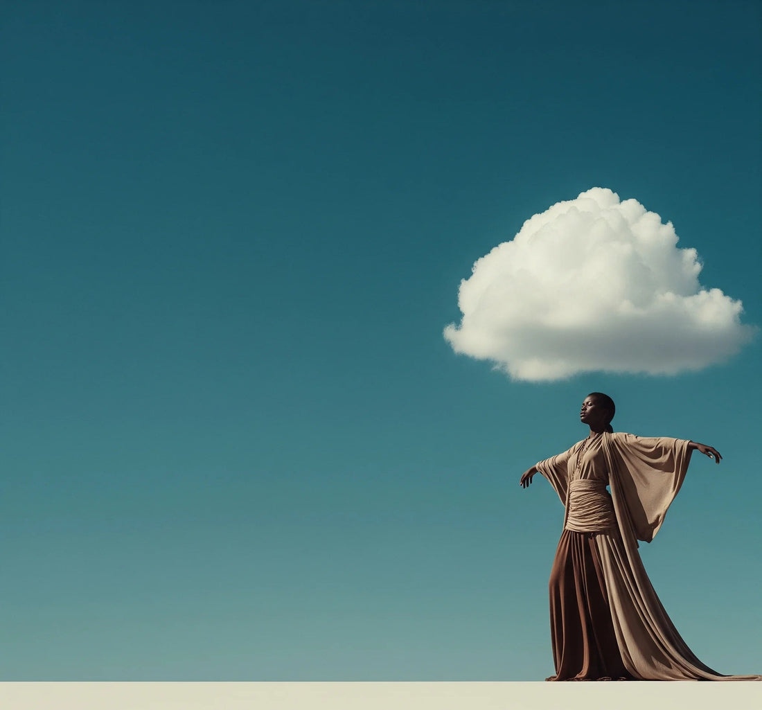 A woman in flowing neutral-toned clothing standing freely beneath a single cloud in a minimalist desert landscape, symbolizing mental clarity, balance, and inner peace